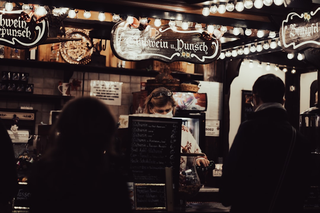 Photo by Serj Sakharovskiy a group of people standing in front of a restaurant